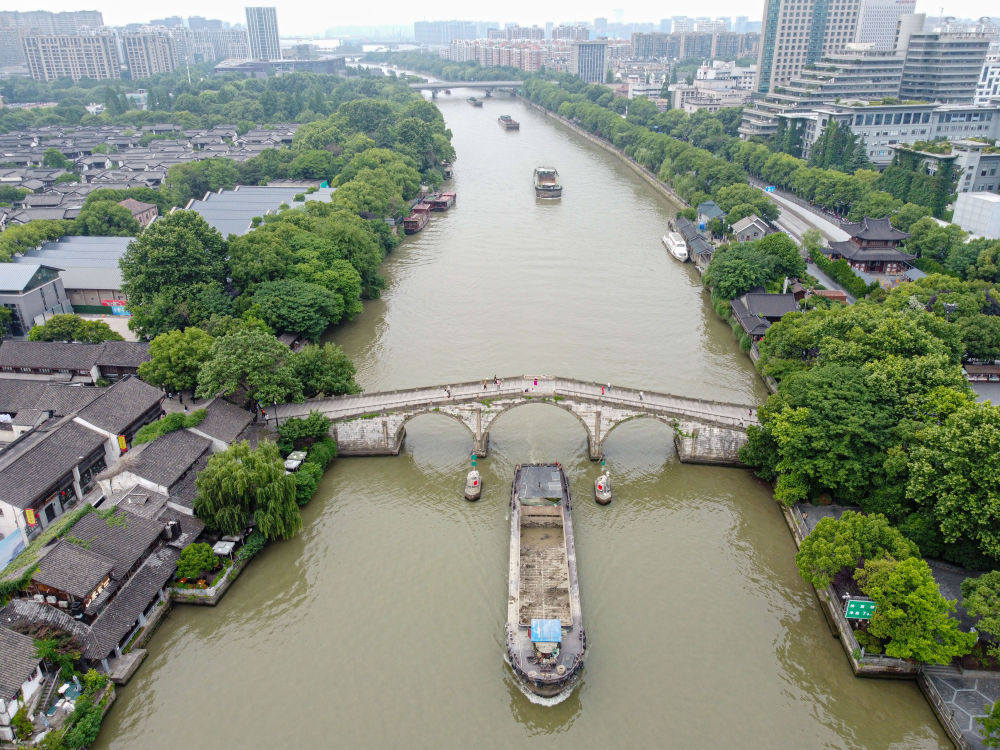 5月27日，一艘貨船駛過(guò)京杭大運(yùn)河南端標(biāo)志建筑杭州拱宸橋。(無(wú)人機(jī)照片)新華社記者江漢 攝