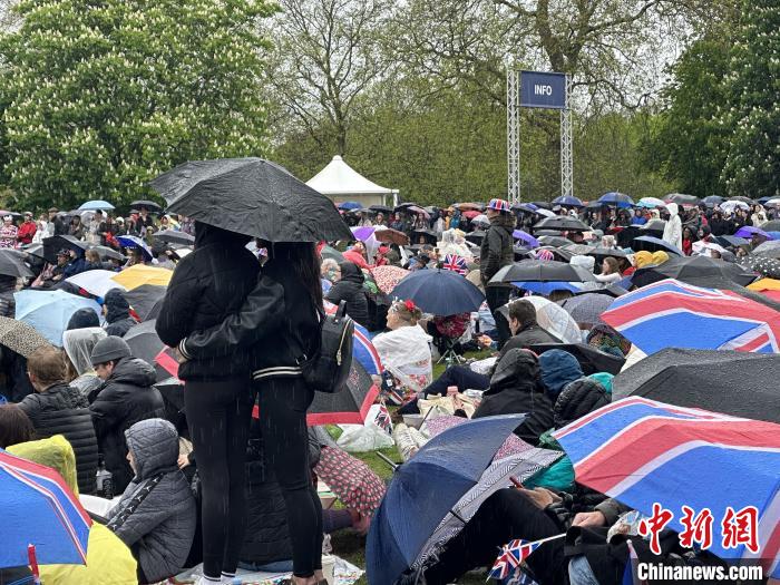 當?shù)貢r間5月6日，英國國王查爾斯三世的加冕儀式舉行。民眾雨中觀看儀式。　歐陽開宇 攝