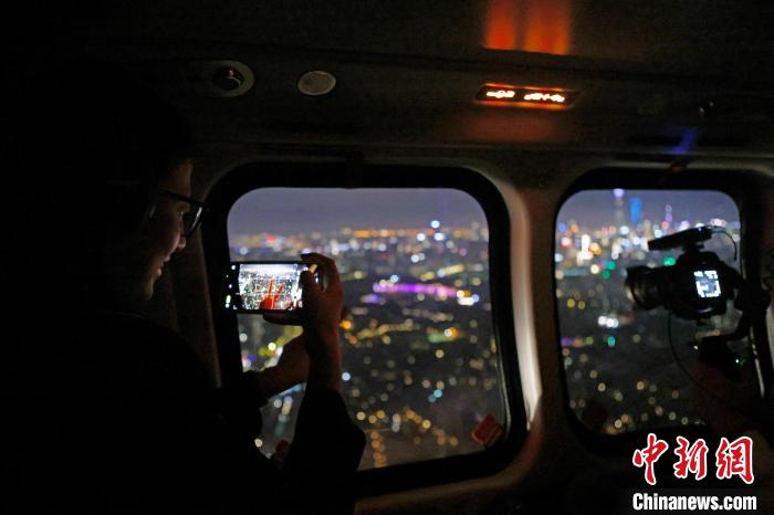 6月3日晚，游客乘坐上海新空直升機有限公司直升機開啟鳥瞰黃浦江空中圓夢之旅，并用手機拍攝城市夜景?！∫罅⑶?攝