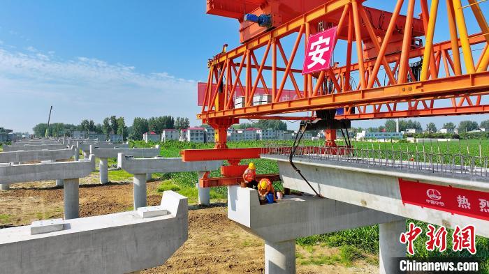 長25米重80噸的箱梁平穩(wěn)、精準地落在S314分離式立交橋25號和26號墩上?！⒂癫?攝