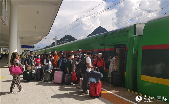 乘坐中老鐵路國(guó)際旅客列車的旅客在老撾瑯勃拉邦站排隊(duì)上車。人民網(wǎng)記者 杜明明攝