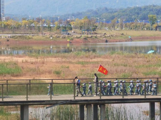 　　10月24日，秋游的幼兒園小朋友在老師帶領(lǐng)下走在清水塘公園里的木橋上。本報(bào)記者 常雯宜攝