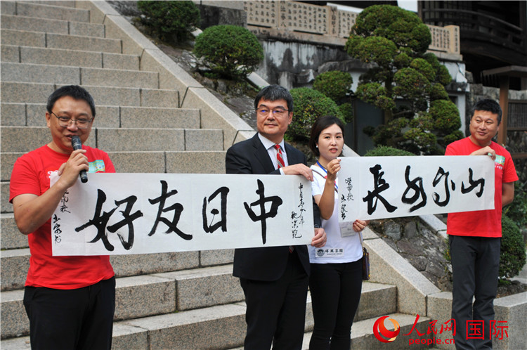 東京中國文化中心主任羅玉泉展示其為本次活動書寫的題詞“中日友好，山高水長”。人民網(wǎng) 蔣曉辰攝