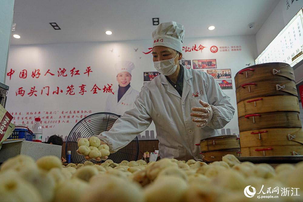 3月31日，在浙江省嵊州市甘霖鎮(zhèn)，嵊州小吃從業(yè)者沈紅平把蒸熟的小籠包晾涼，打包冷藏售賣(mài)。人民網(wǎng) 章勇濤攝