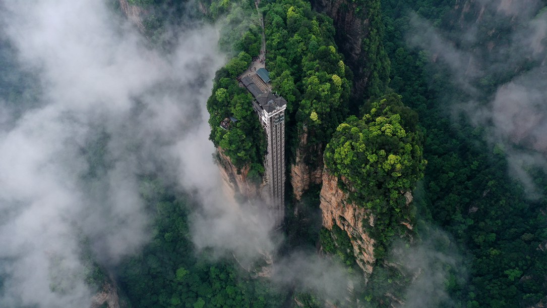 位于張家界武陵源景區(qū)的百龍?zhí)焯蓁偳对谠旗F繚繞的峰林間，雄偉壯觀。吳勇兵攝