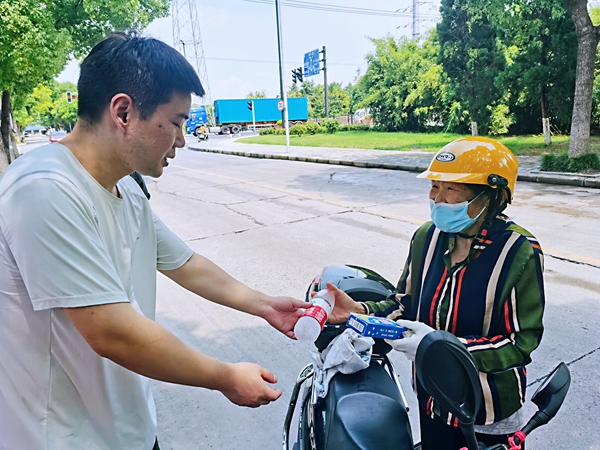 何超為過路的老人送上礦泉水和冷飲。人民網(wǎng)記者 王繼亮攝