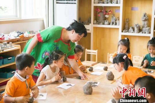 圖為劉雪玲正在給幼教中心的孩子上泥塑課?！＄娦?攝