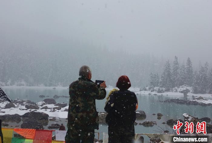 游客欣賞雪中然烏湖。　冉文娟 攝