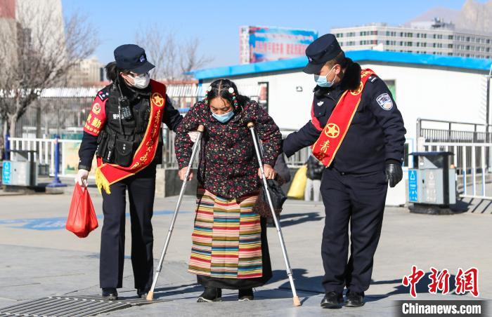 圖為拉薩鐵路公安民警幫助老人進(jìn)站乘車。　胡安鵬 攝