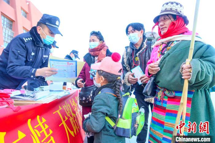 圖為拉薩鐵路公安民警向旅客發(fā)放乘車安全宣傳資料?！↑S飛 攝