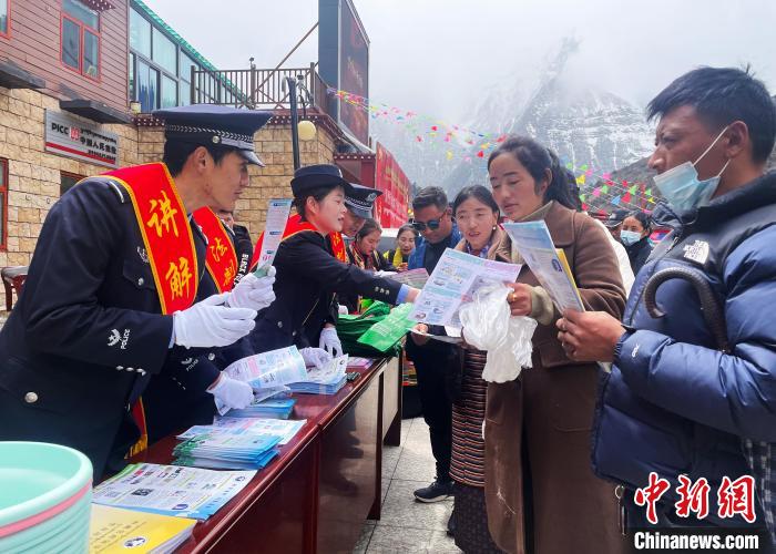 圖為山南玉麥邊境派出所民警為轄區(qū)群眾發(fā)放法律知識宣傳單?！＄婗?　攝