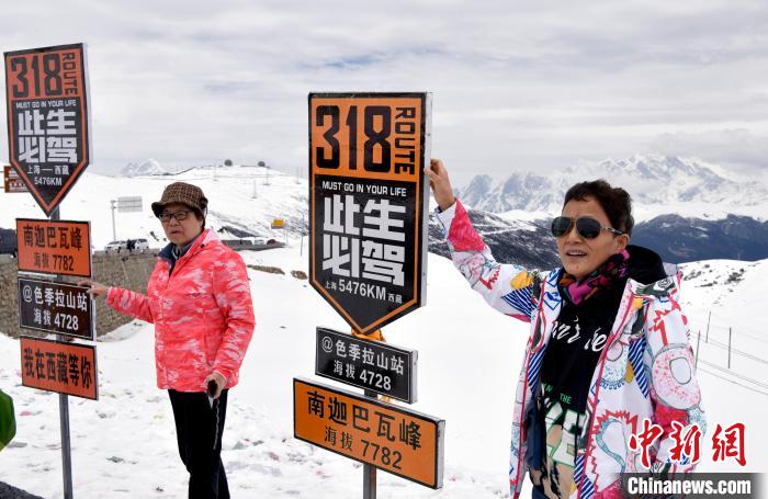 圖為5月14日，西藏林芝色季拉山觀景臺(tái)，游客與南迦巴瓦峰合影?！±盍?攝