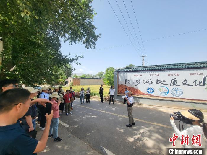 圖為中國地質(zhì)大學(xué)(北京)教授張緒教介紹村落情況。　胡友軍 攝