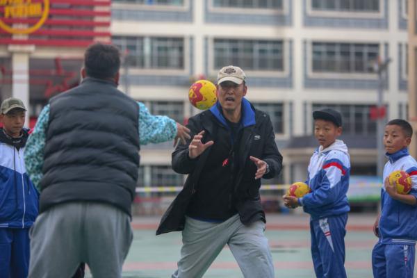 在高原上教孩子們打手球，“慢慢兒來，甭著急！”