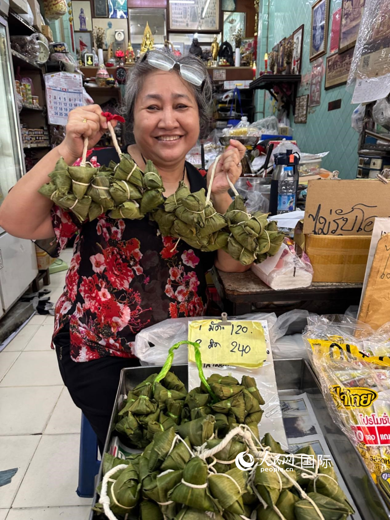 商家向顧客介紹“吉掌”（粽子的一種，一串一串，個(gè)頭較小）。人民網(wǎng)記者 簡承淵攝