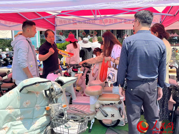 某電動自行車品牌工作人員向消費者介紹以舊換新相關情況。人民網記者 杜燕飛攝