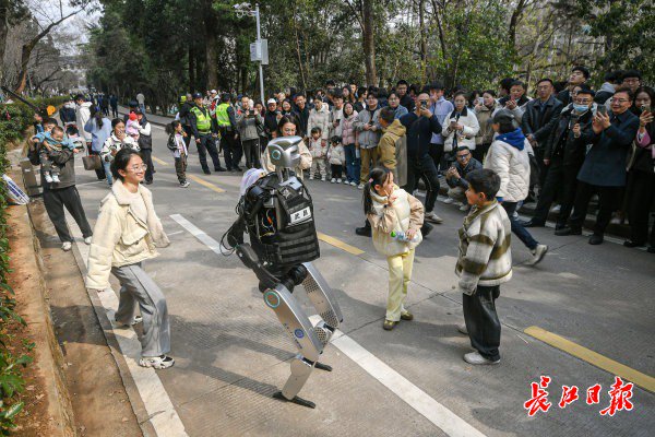 “智警小珞”人形機(jī)器人和小朋友們斗舞。長江日報(bào)記者史偉 攝