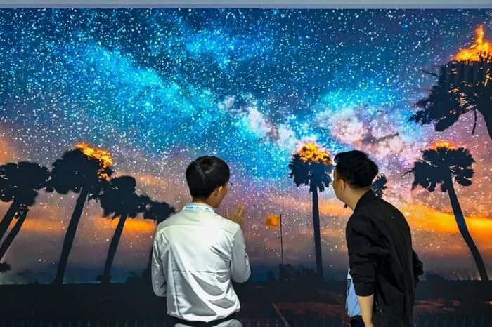 長春光博會希達電子展區(qū)，一位工作人員正在給一位觀眾講解。（長春新區(qū)供圖）