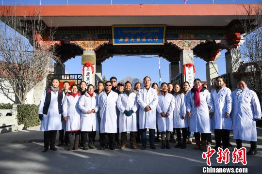 圖為該校師生在更名后的西藏藏醫(yī)藥大學校門前合影留念?！『闻罾?攝