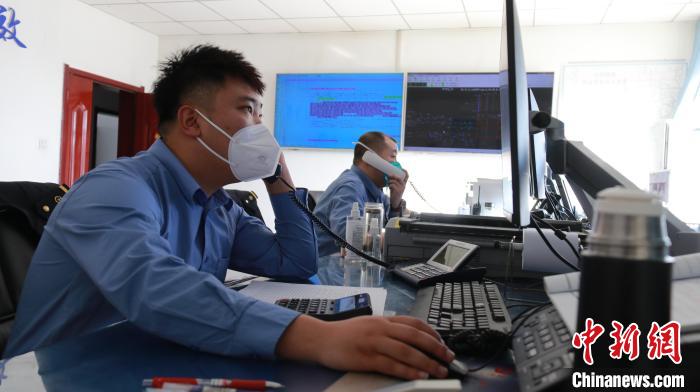 圖為貨運(yùn)調(diào)度人員與外勤工作人員聯(lián)系掌握車輛裝載情況。　李生燕 攝