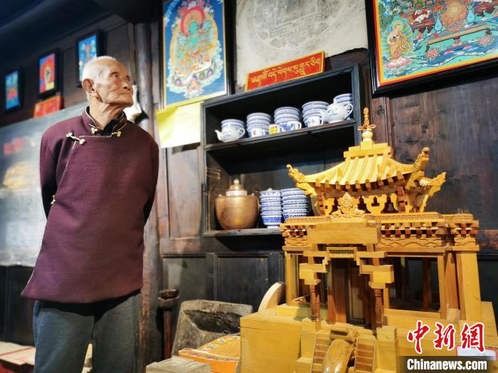 圖為古堡內的藝人桑杰展示自己的雕刻作品?！?zhí)砀?攝