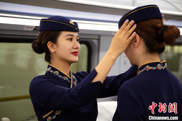 圖為青藏鐵路西格段“復興號”動車組乘務員互相整理新制服。　李磊 攝