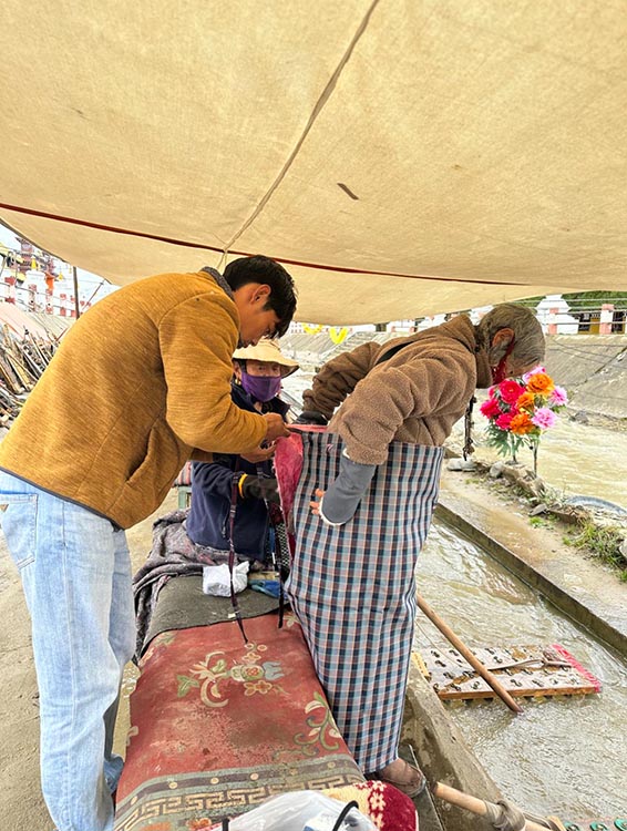 扎西奪爾登為路邊老人送去保暖圍腰。阿壩州文明辦供圖