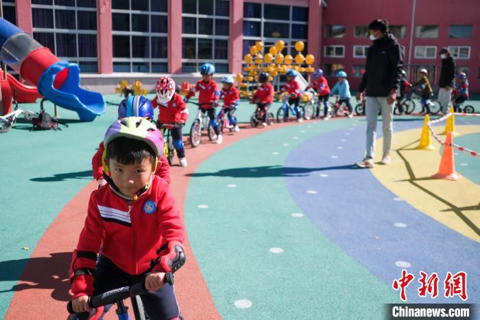 圖為拉薩市實驗幼兒園孩子們在教練的指導(dǎo)下練習(xí)滑步車。　何蓬磊 攝