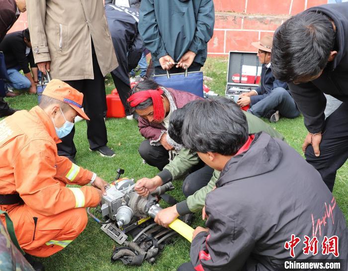 圖為森林消防員為護林員講解滅火裝備的使用方法?！〔际猩窒乐ш?供圖