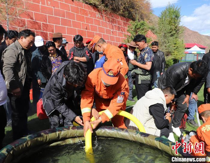 圖為森林消防員為護林員講解滅火裝備的使用方法?！〔际猩窒乐ш?供圖