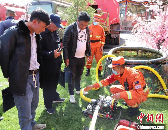 圖為森林消防員為護林員講解滅火裝備的使用方法?！〔际猩窒乐ш?供圖