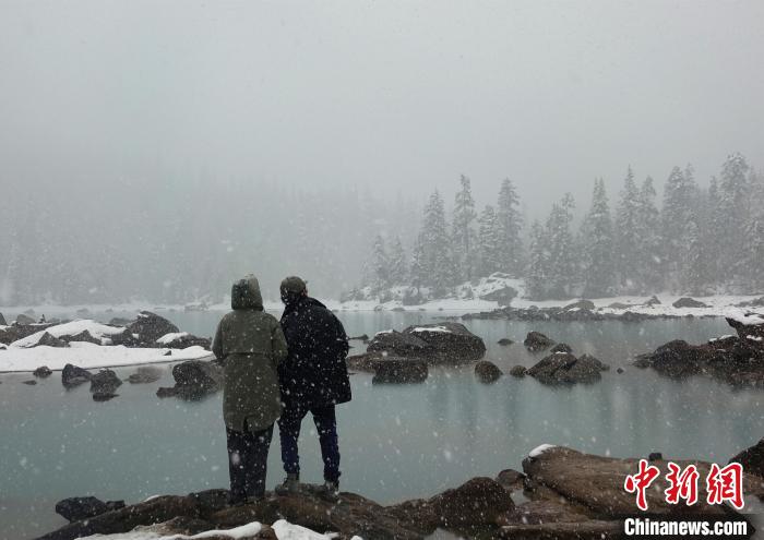 游客欣賞雪中然烏湖。　冉文娟 攝