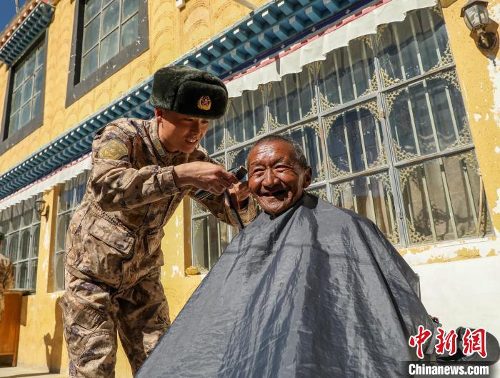 圖為阿里軍分區(qū)某邊防團官兵為駐地群眾理發(fā)迎藏歷新年。　旦增倫珠 攝