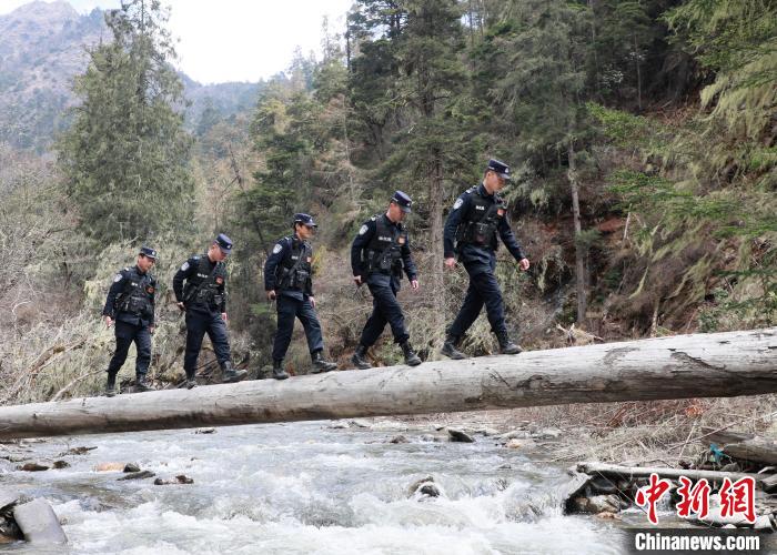 山南邊境管理支隊玉麥邊境派出所民警邊境巡邏途中走過河道上“獨木橋”。　鄭琦山 攝