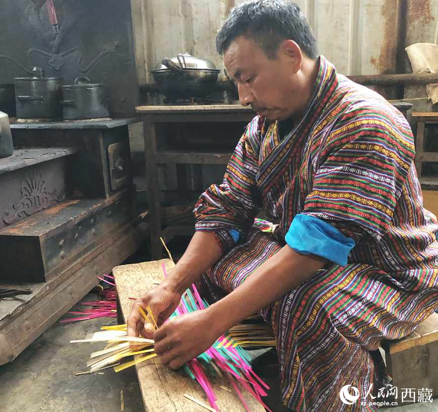 門巴族漢子愛明正在編織藤竹品。