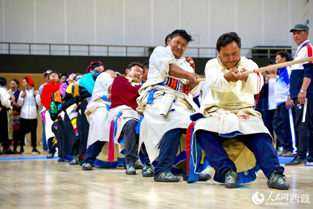 身著民族服裝的農(nóng)牧民選手在拔河比賽現(xiàn)場。